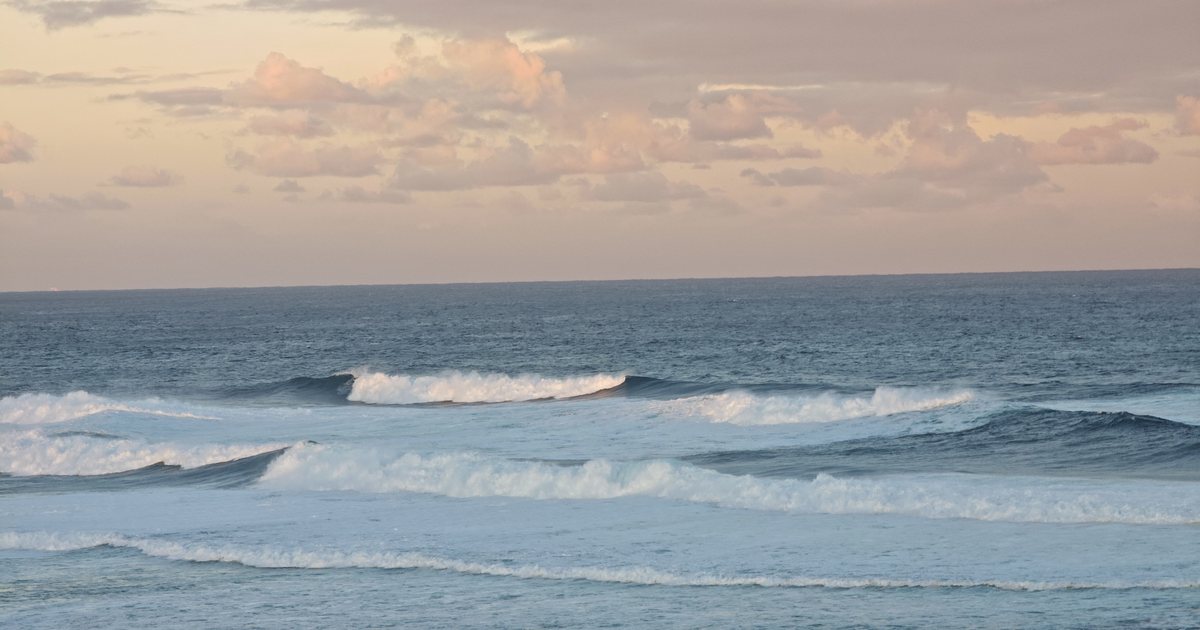 Ocean waves beneath a pastel evening sky